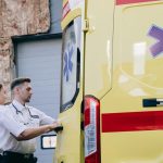 Zwei Sanitäter an der Hecktür eines Krankenwagens